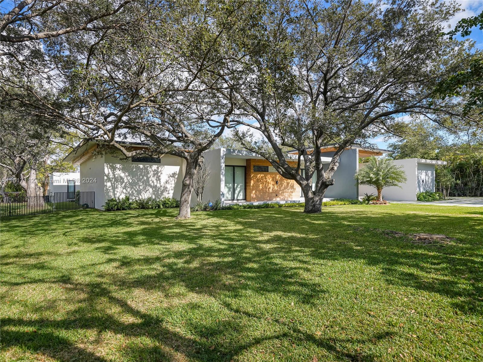 7825 Southwest 128th Street Pinecrest, FL 33156 - Photo 37 of 40 a front view of a house with a garden