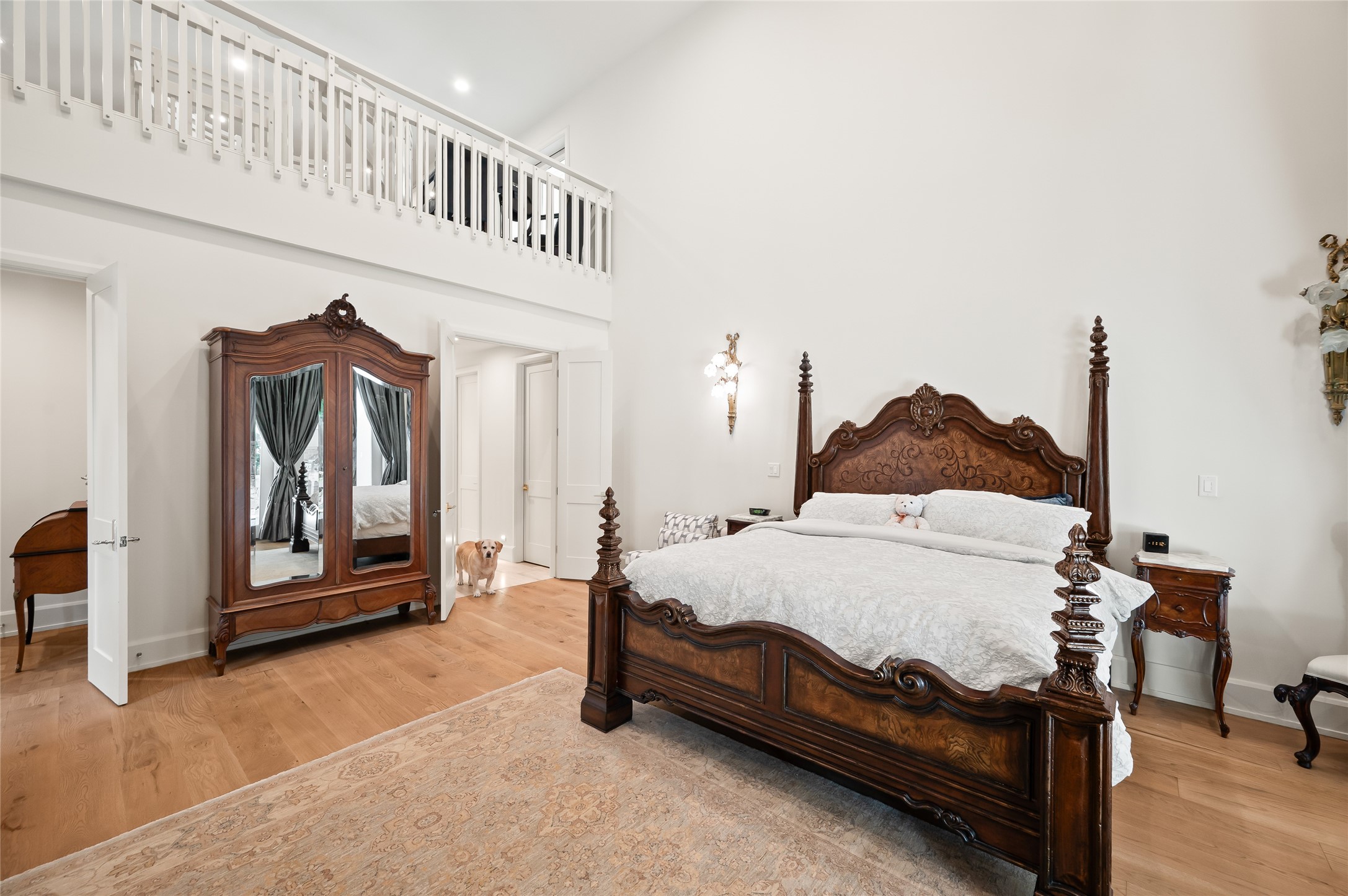 11518 Shadow Way Street Houston, TX 77024 - Photo 19 of 50 The grand primary suite features soaring ceilings, backyard access to the hot tub, and a private spiral staircase leading to an upstairs loft. A true sanctuary, the room is both serene and architecturally striking.