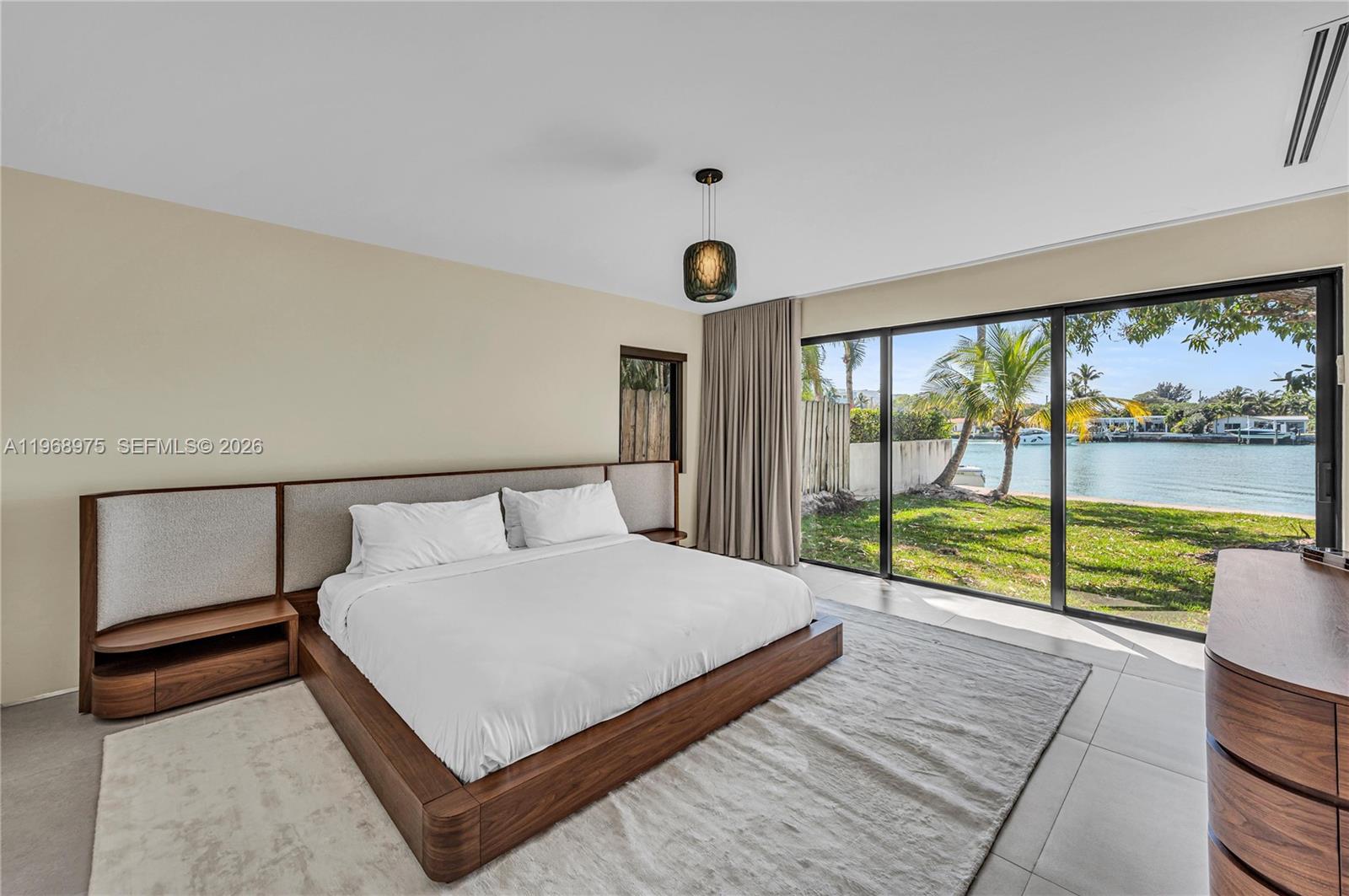 1170 South Biscayne Point Road Miami Beach, FL 33141 - Photo 20 of 48 a bed sitting in a bedroom next to a large window