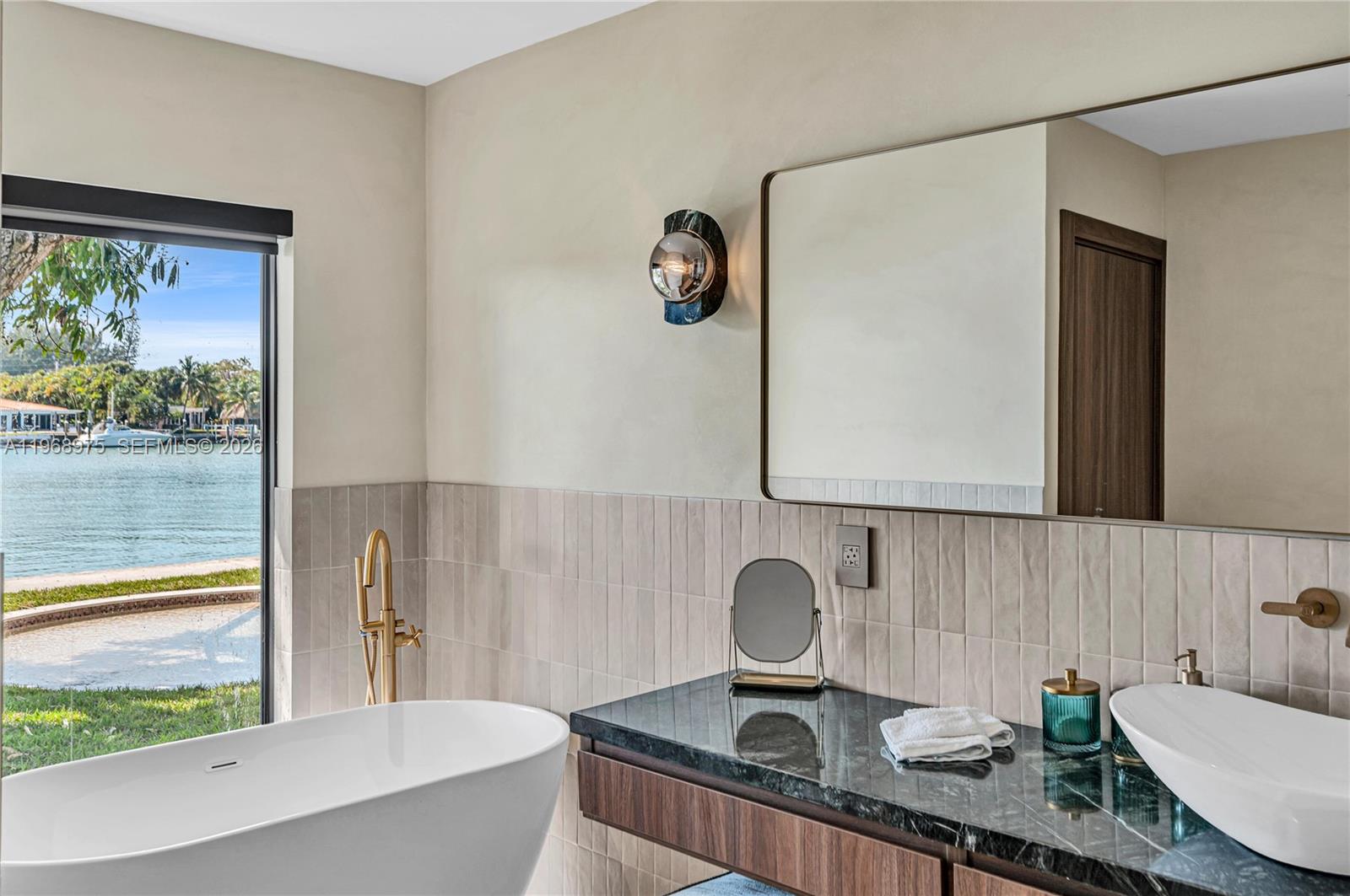 1170 South Biscayne Point Road Miami Beach, FL 33141 - Photo 24 of 48 a bathroom with a granite countertop sink and a mirror