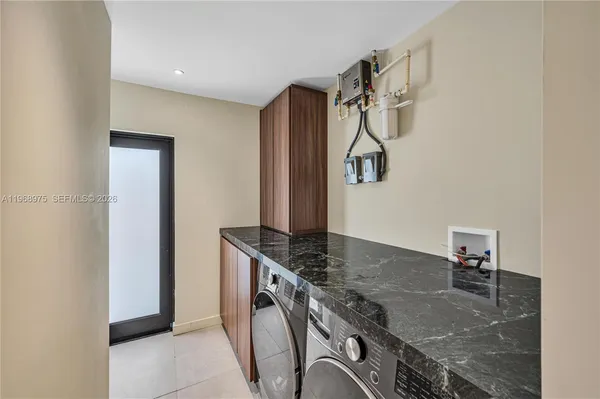 a kitchen with granite countertop a sink a stove and refrigerator