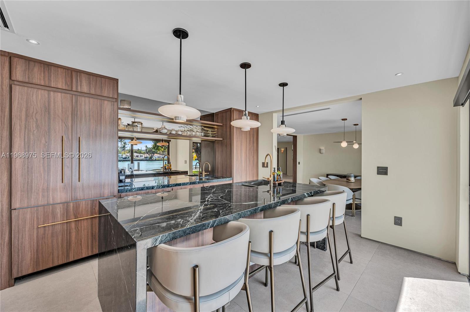 1170 South Biscayne Point Road Miami Beach, FL 33141 - Photo 7 of 48 a kitchen with stainless steel appliances kitchen island granite countertop a table and chairs in it