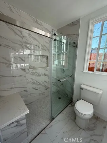 a bathroom with a toilet and a shower