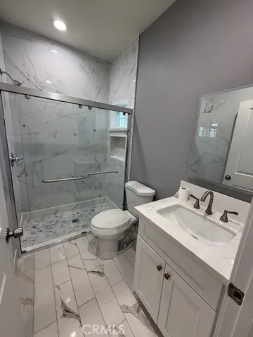 a bathroom with a granite countertop sink toilet and shower