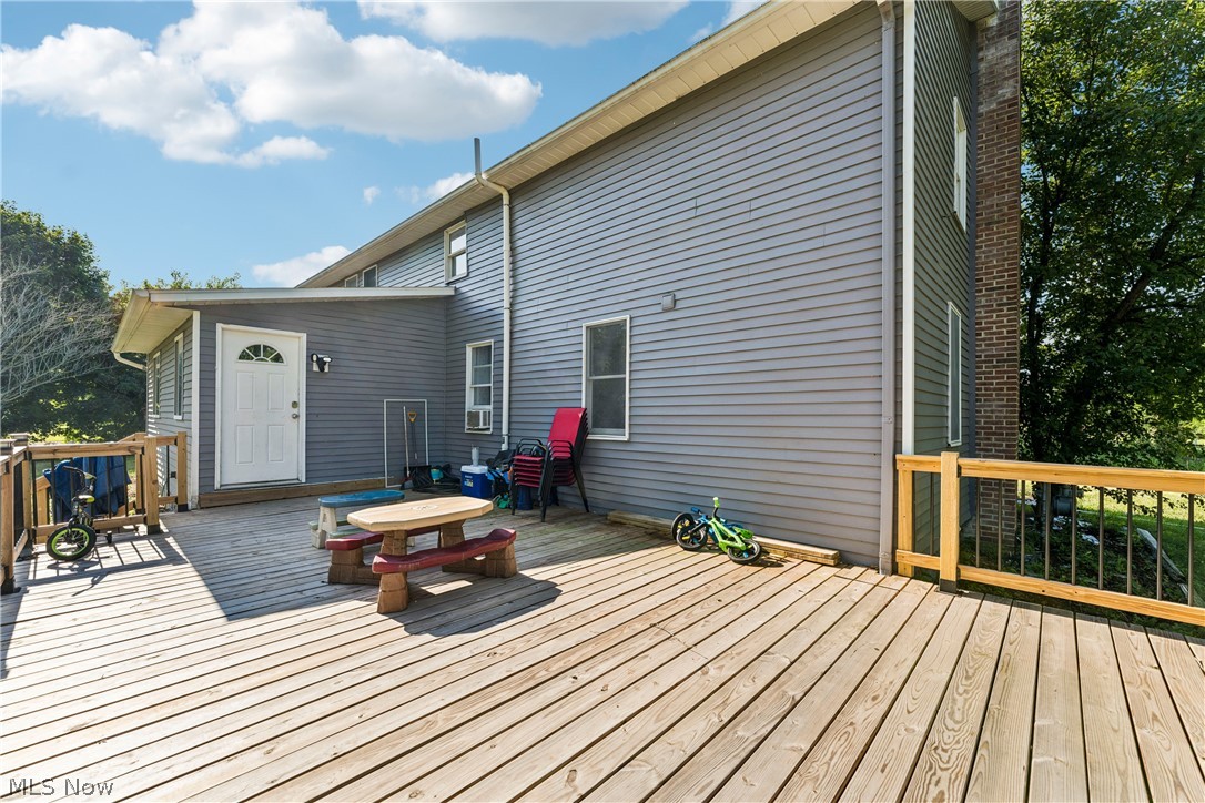 6711 Norwalk Road Medina, OH 44256 - Photo 34 of 46 Large wooden deck with natural wood railing, black metal balusters and back door entrance