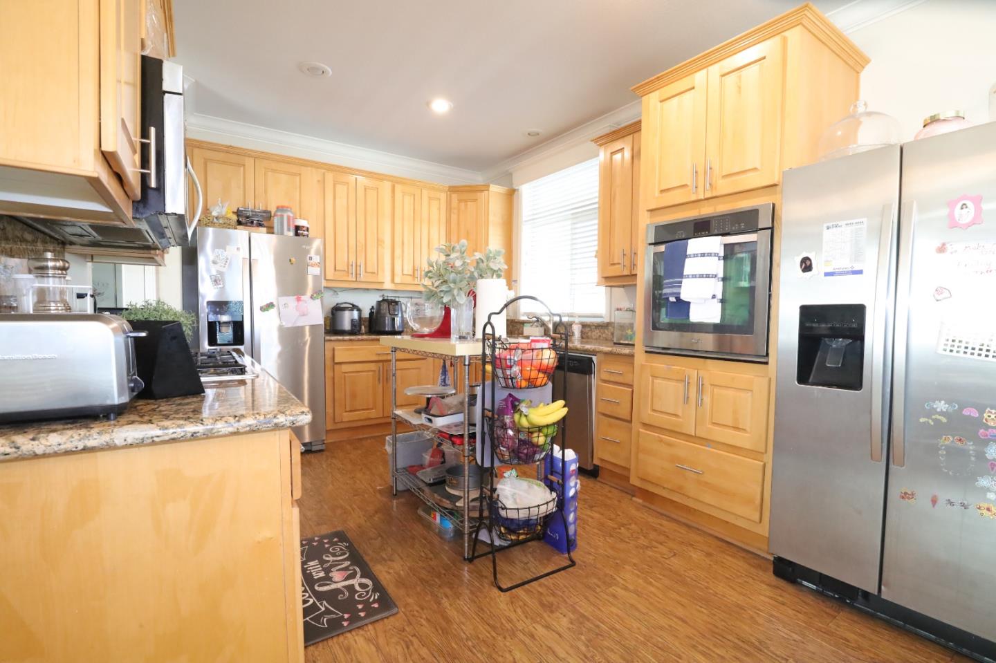5450 Monterey Road, Unit 182 San Jose, CA 95111 - Photo 11 of 33 a kitchen with stainless steel appliances kitchen island granite countertop a refrigerator a stove and a microwave with cabinets