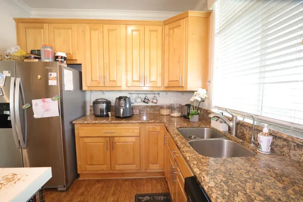 a kitchen with granite countertop a sink a counter top space and cabinets