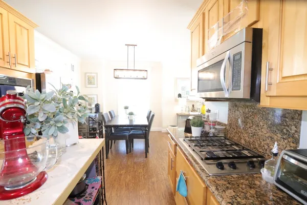 a kitchen with stainless steel appliances granite countertop a stove a sink and a dining table with granite countertops