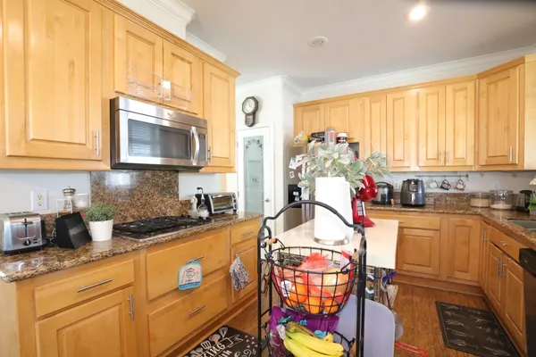a kitchen with stainless steel appliances granite countertop a stove a sink and a microwave