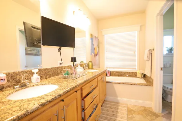 a bathroom with a granite countertop sink and a large mirror