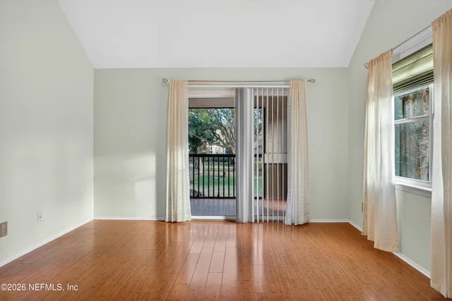 a view of a livingroom with a ceiling fan & windows