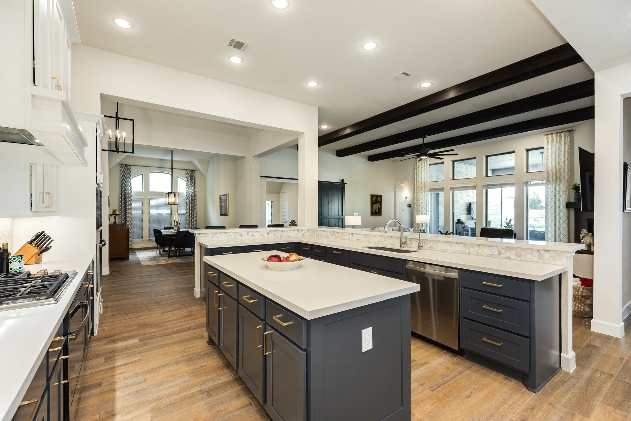 9538 Sanger Way Manvel, TX 77578 - Photo 49 of 50 Open floor plan showcasing a seamless flow from the kitchen to the formal dining area, family room, and a game room featuring a custom sliding barn door.