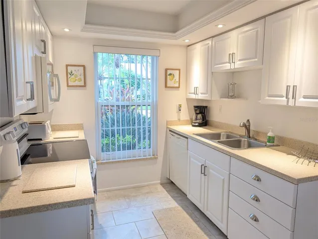 a kitchen with granite countertop a sink and a stove top oven