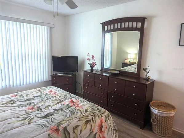 a bedroom with a bed and a mirror on dresser