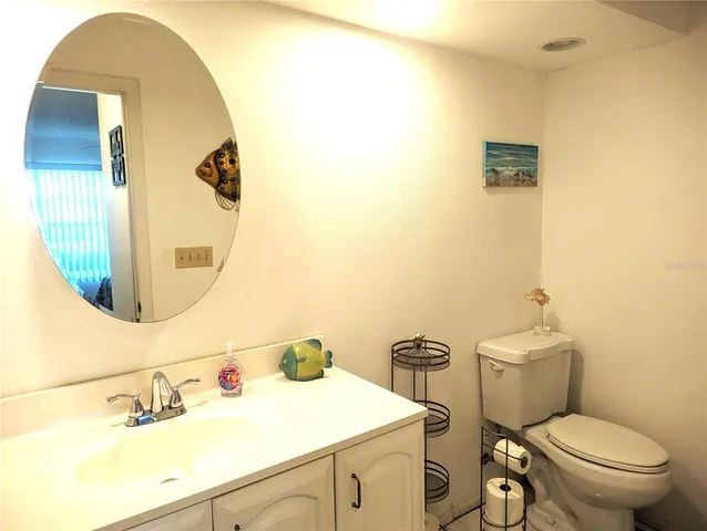 a bathroom with a sink mirror vanity and toilet