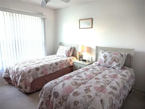 a bedroom with two beds and a lamp on dresser