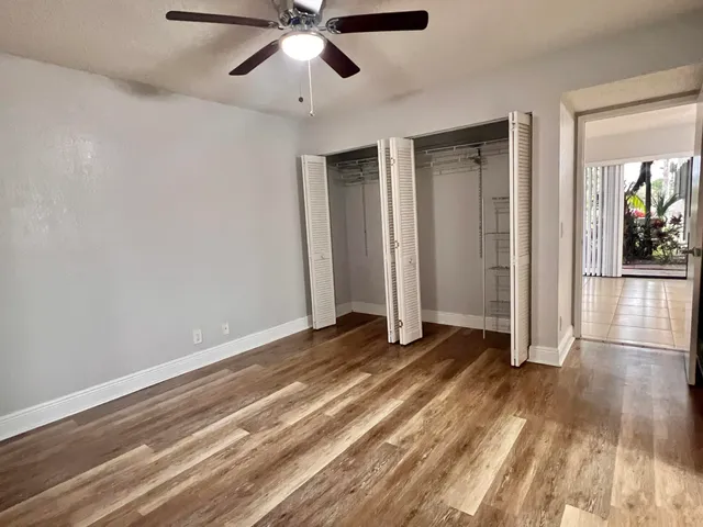 an empty room with wooden floor and hallway
