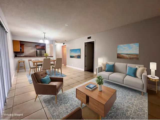 a living room with furniture and a view of kitchen