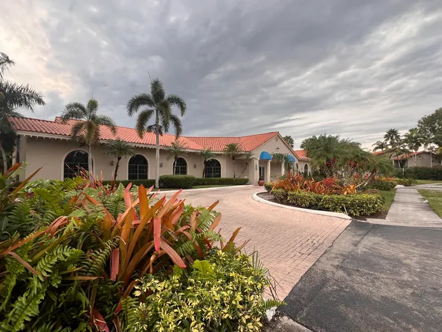 a front view of a house with a yard and potted plants