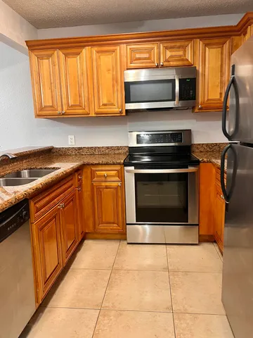 a kitchen with stainless steel appliances granite countertop a stove top oven microwave and cabinets
