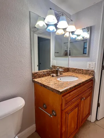 a bathroom with a granite countertop sink and a mirror