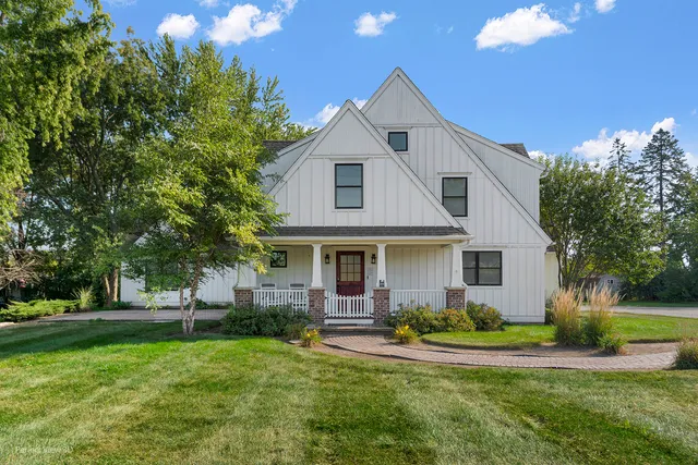 a front view of a house with a yard and trees