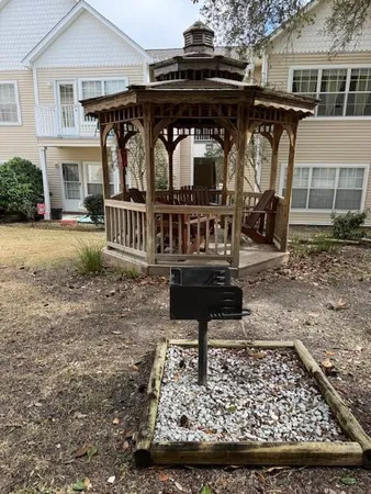 a view of a small house with yard and furniture