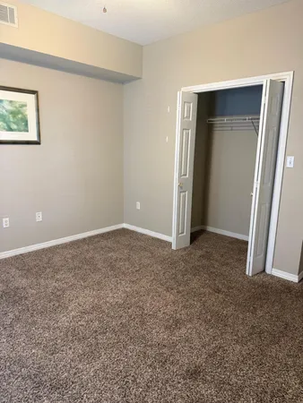 an empty room with closet and a bathroom