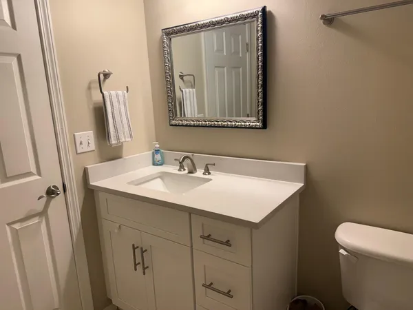 a bathroom with a sink toilet and mirror
