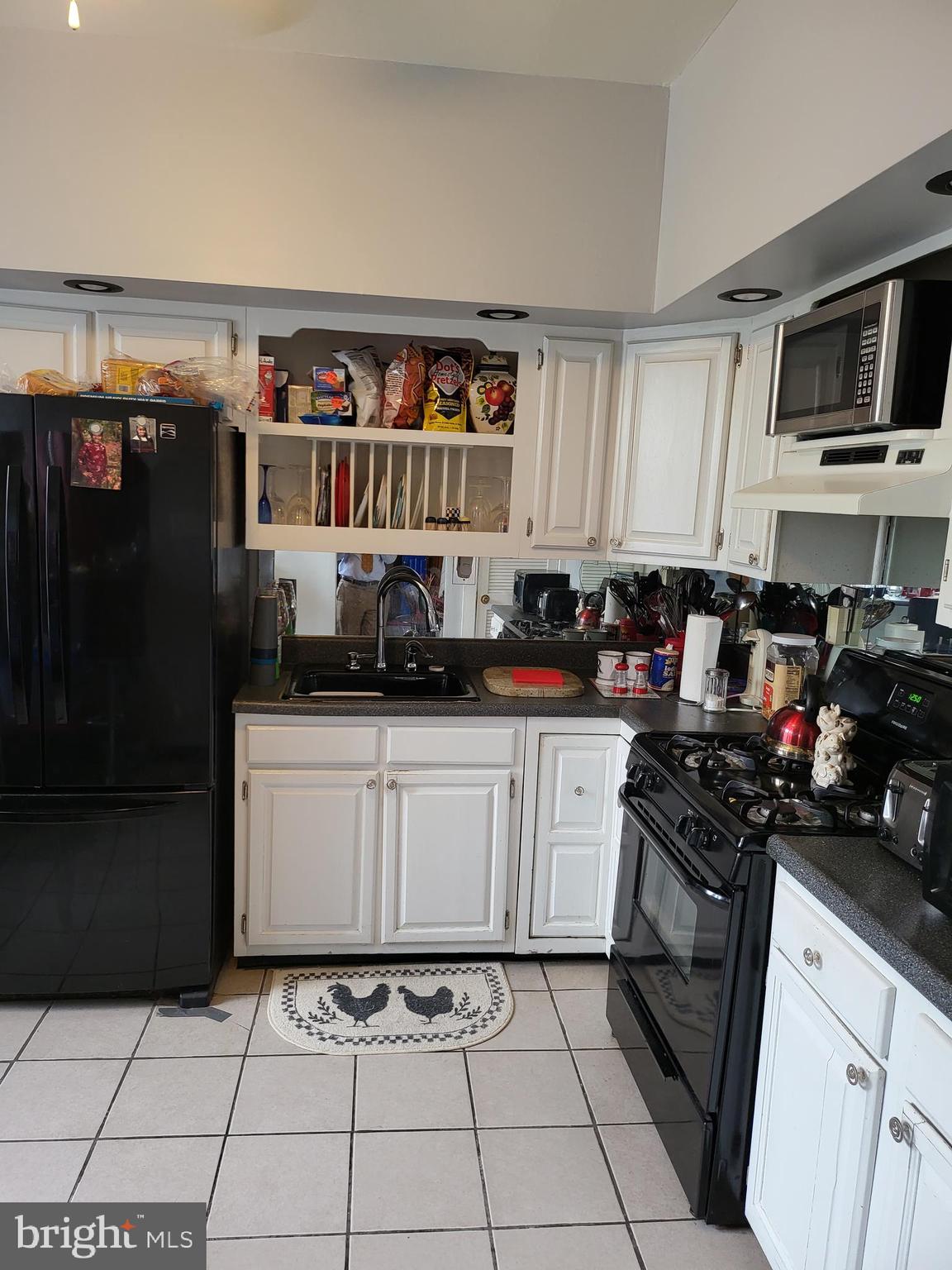 935 Howe Street Camden, NJ 08104 - Photo 6 of 14 a kitchen with a black white cabinets and black appliances
