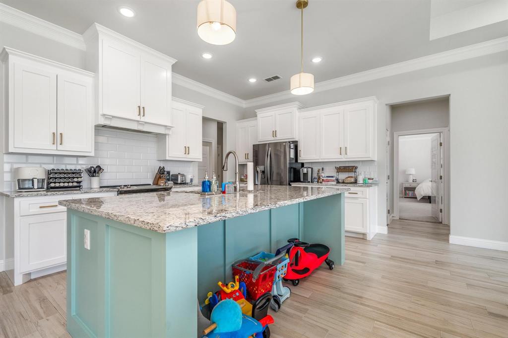 349 Garth Ridge Drive Abilene, TX 79602 - Photo 4 of 33 a kitchen with kitchen island granite countertop a sink cabinets and wooden floor