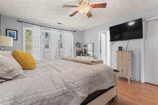 a bedroom with a bed flat screen tv and a chandelier