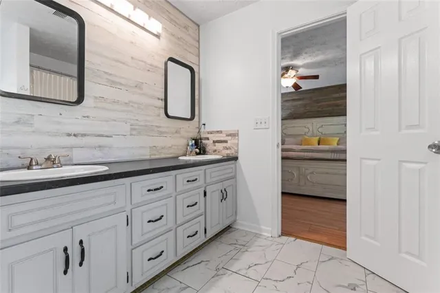 a spacious bathroom with a granite countertop sink and a mirror