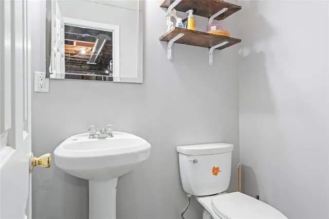 a bathroom with a toilet sink and mirror