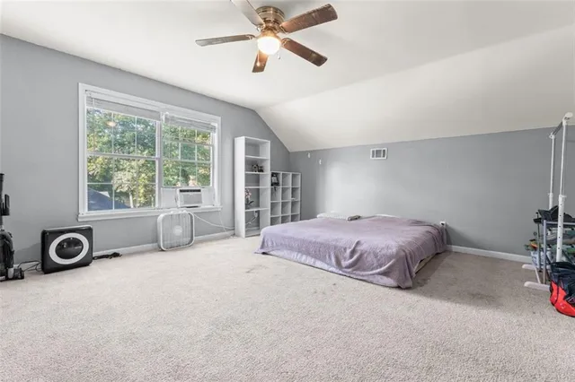 a spacious bedroom with a bed and a chandelier