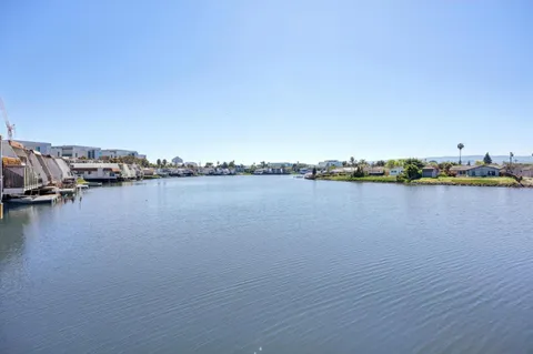 a view of a ocean with boats and trees in the background