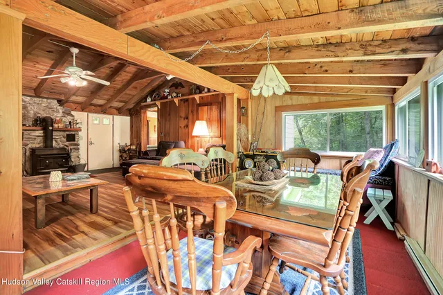 a view of a dining room with furniture a chandelier and large windows