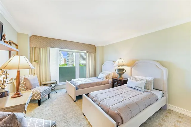 a bedroom with two beds and large window