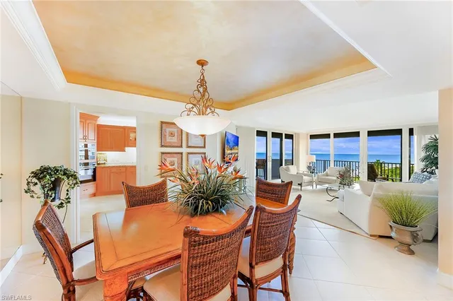 a dining room with furniture potted plants and a chandelier