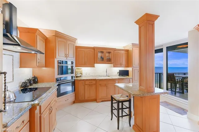a kitchen with stainless steel appliances granite countertop a sink and a refrigerator