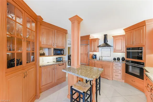 a kitchen with stainless steel appliances kitchen island granite countertop a stove top oven a sink and a refrigerator