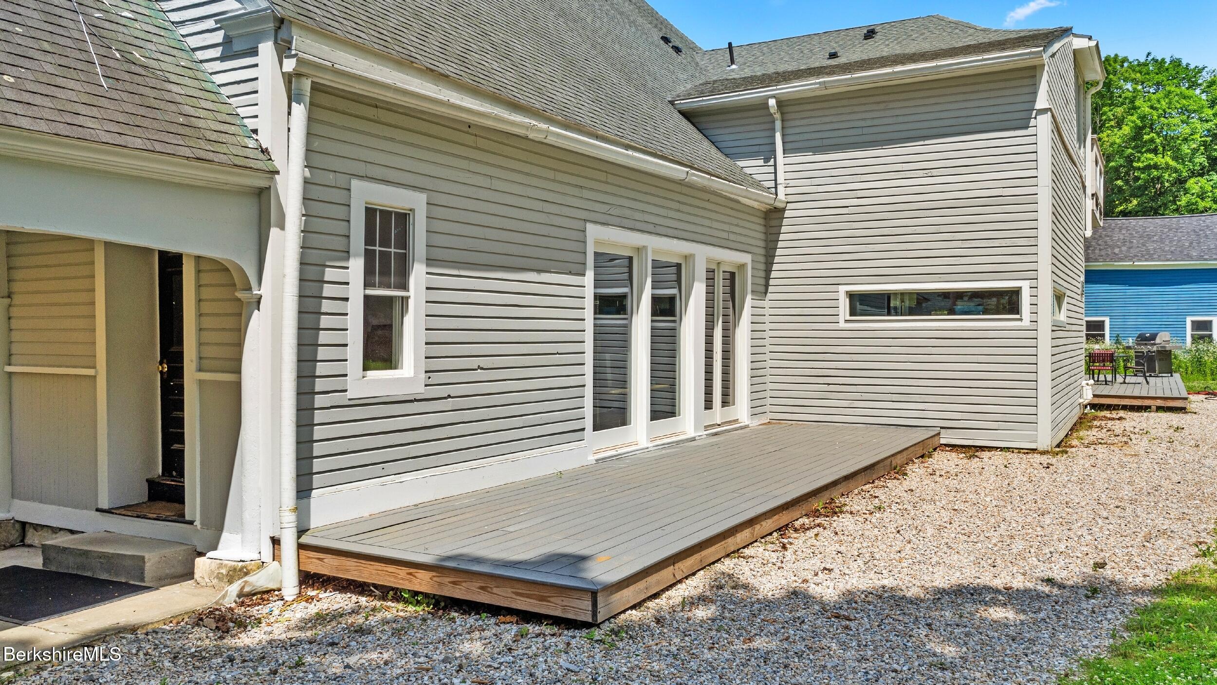 160 High Street Lee, MA 01238 - Photo 11 of 68 a view of a house with a door and wooden bench