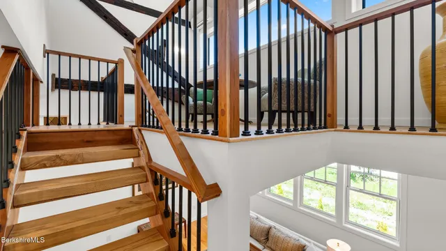 a view of staircase with lots of frames on wall and a large window