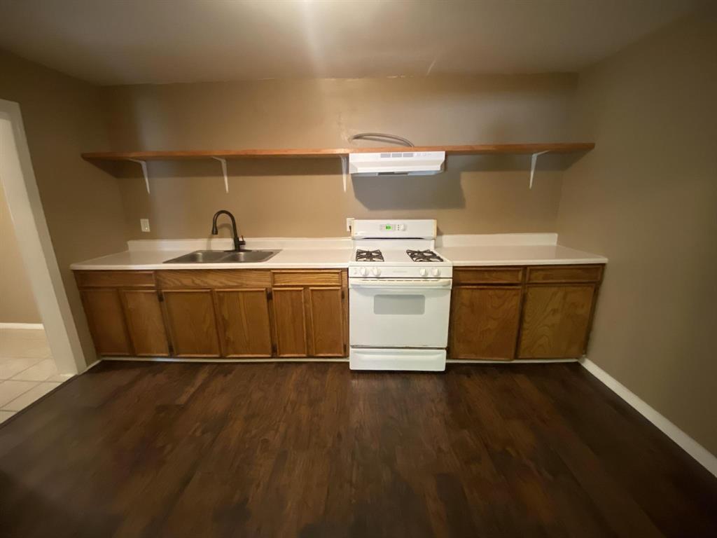625 York Street, Unit B Athens, TX 75751 - Photo 11 of 15 Kitchen featuring gas range gas stove, open shelves, wood finish cabinetry, and light countertops