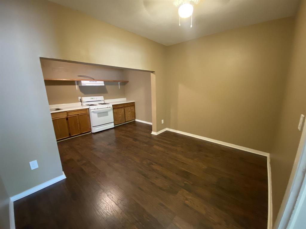 625 York Street, Unit B Athens, TX 75751 - Photo 10 of 15 Kitchen featuring light countertops, wood finish cabinetry, gas range gas stove, dark wood-style floors, and a ceiling fan