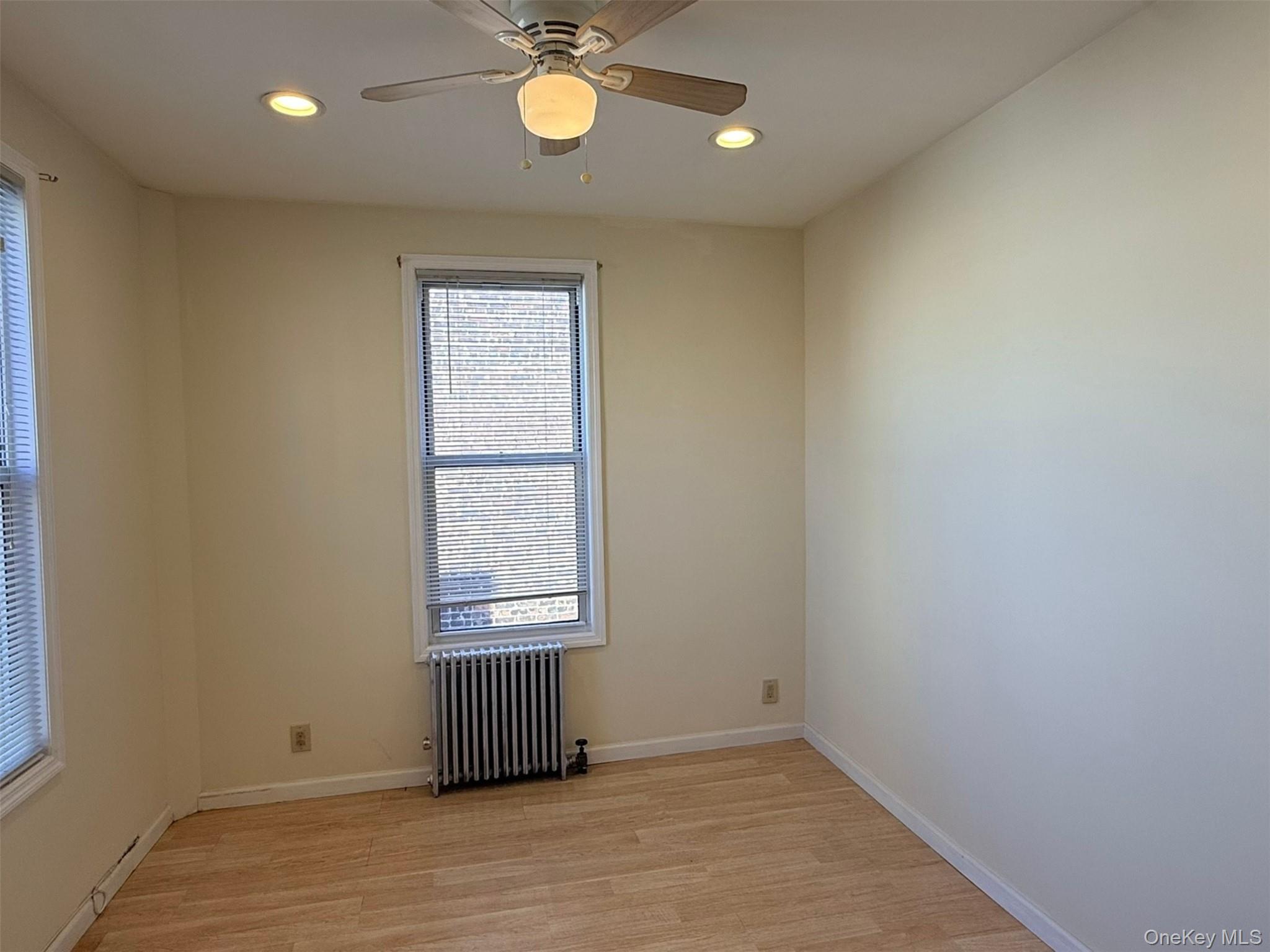 52-05 35th Street, Unit 2 Queens, NY 11101 - Photo 14 of 32 an empty room with wooden floor and windows