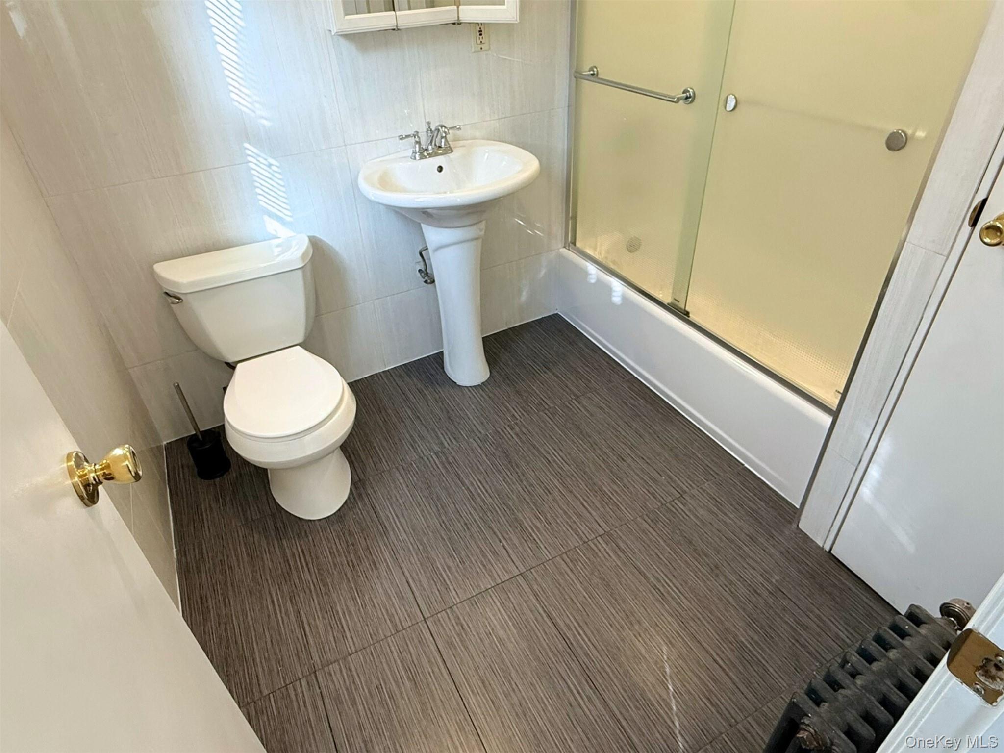 52-05 35th Street, Unit 2 Queens, NY 11101 - Photo 29 of 32 a bathroom with a sink and a mirror