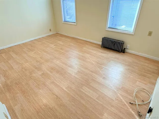 an empty room with windows and ceiling fan