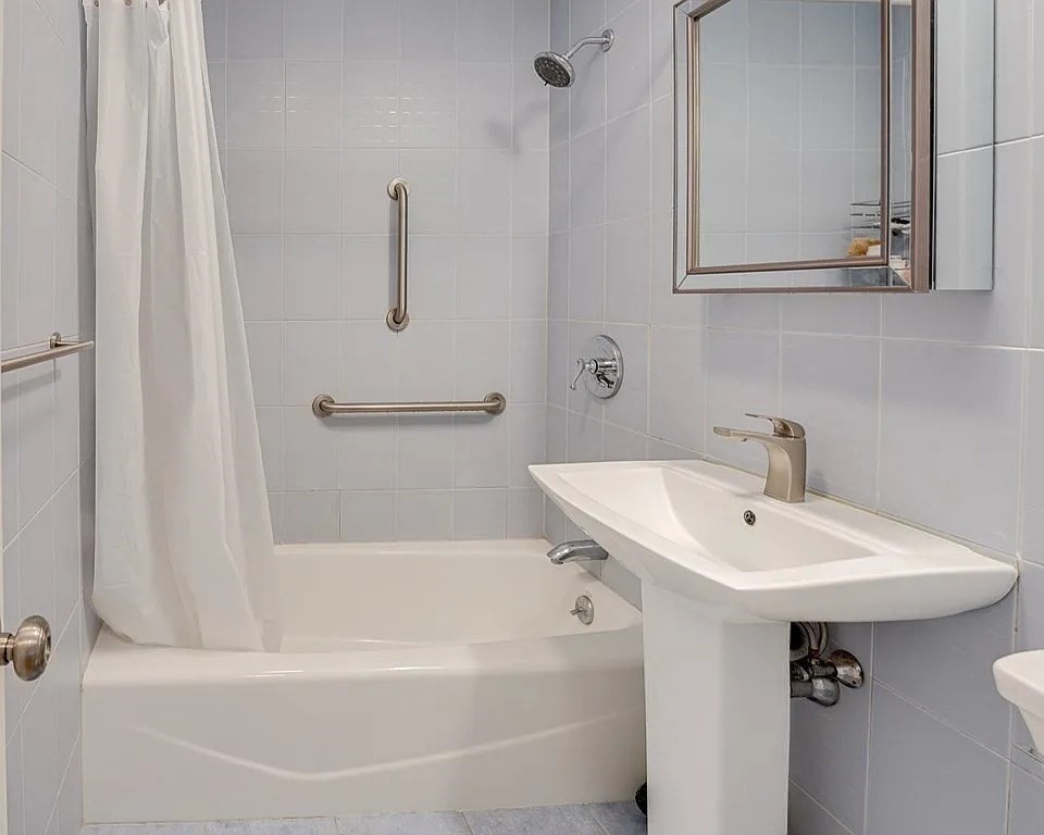 83 Nicholas Road, Unit H Framingham, MA 01701 - Photo 9 of 11 a bathroom with a sink a mirror and a bathtub