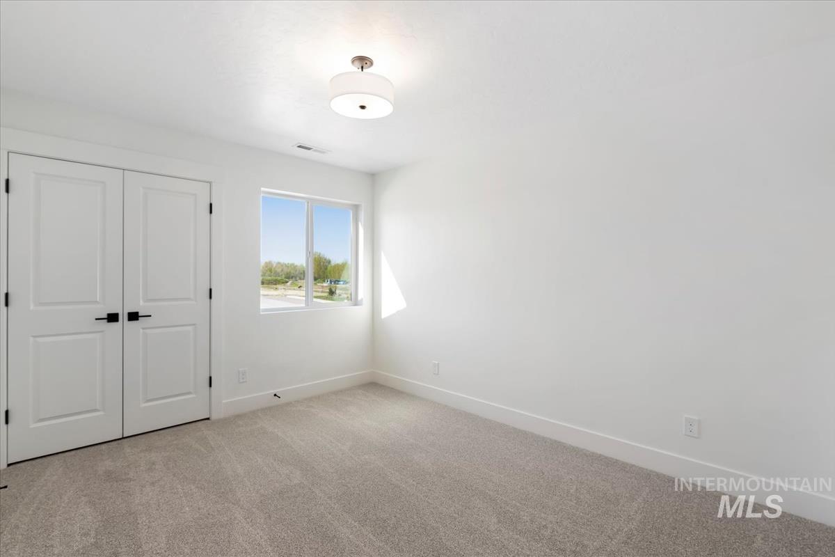 768 South Calhoun Lane Star, ID 83669 - Photo 26 of 36 Neutral-toned carpeting, white walls, and a window providing natural illumination